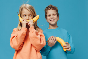 funny, cute children, a boy and a girl are standing on a blue background in bright clothes and...