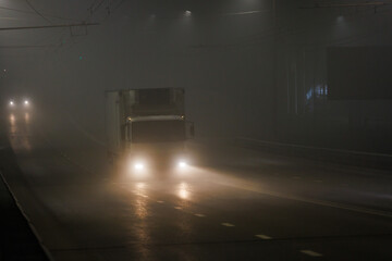 small white hoodless dry van truck moving on night foggy summer road