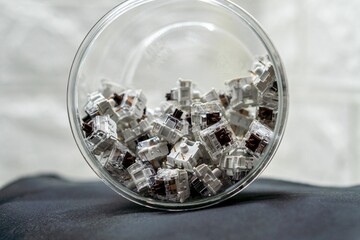 Closeup of mechanical keyboard switches piled in a transparent jar