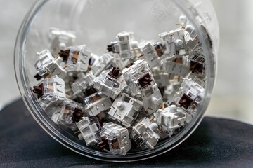 Closeup of mechanical keyboard switches piled in a transparent jar