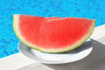 Slice of fresh juicy watermelon on white plate near swimming pool outdoors, closeup
