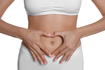 Woman in underwear making heart with hands on her belly near white background, closeup. Healthy...