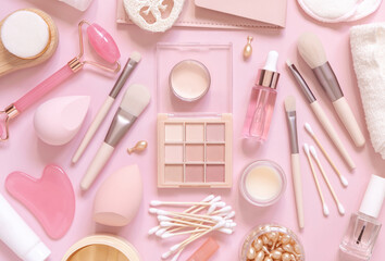 Natural skin care products and decorative cosmetics on light pink, top view