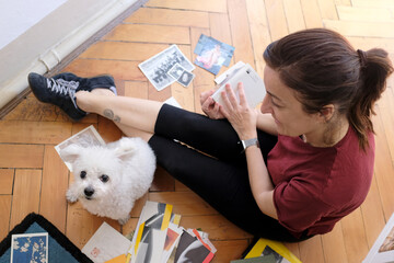 woman sitting with her little dog looks at the scrapbooks