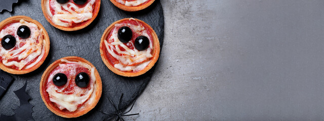 Cute monster tartlets served on grey table, flat lay with space for text. Banner design