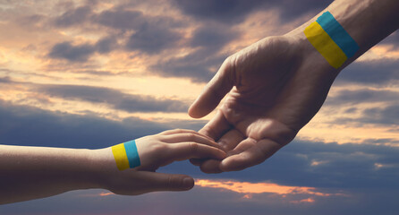 Help for Ukraine. Man and child holding hands with drawings of Ukrainian flag and beautiful sky...