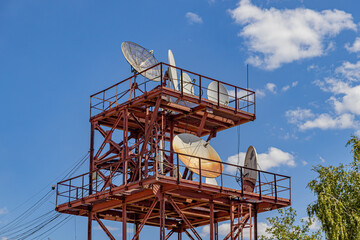 A metal tower on which various satellite antennas are located