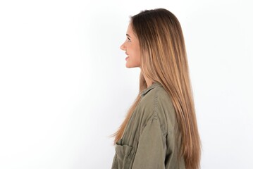 Profile portrait of nice young beautiful woman wearing green overshirt over white background look...