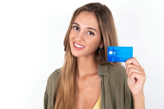 Close up photo of optimistic young beautiful woman wearing green overshirt over white background hold card
