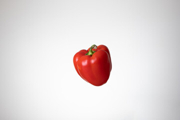 Fresh whole red bell pepper. Close up studio shot, isolated on a white background