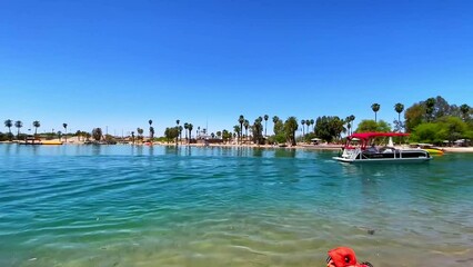 Lake Havasu city beach with boats and palm trees under the blue sky on a sunny day