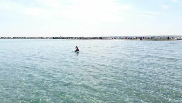 Air view. Young woman are having fun. Get up, row in the sea. SUP. exercising while standing on his paddleboard