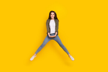 Full size photo of energetic good mood attractive female jumping up have fun isolated on yellow color background