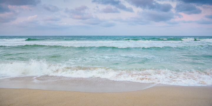 velvet season seascape. waves rushing on the beach. cloudy sky before the evening storm