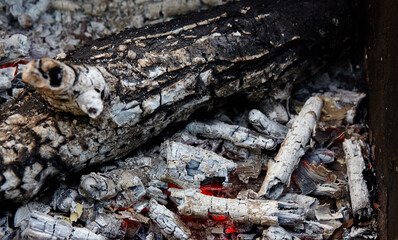 Smoldering charcoal in a barbecue. Scattered pieces of embers in the hearth mixed with ash. Ashes...