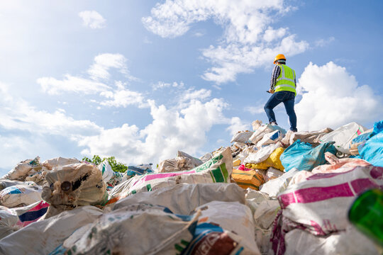 A manager holds a tablet on top of a pile of recycling bottles at recycling plant. Recycle waste business concept. Recycle waste.