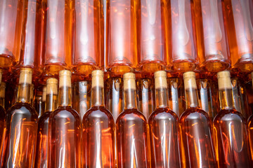 Many glass wine bottles on wine shelves. interior in distillery. Row of Stacked wine bottles in cellar to ferment the wine.