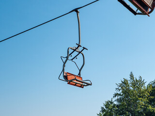 Orange chair lift in summertime with clear blue