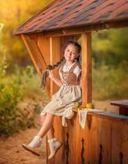 A girl in a sundress, a peasant woman's outfit, rural clothes walks in nature. The girl is sitting...