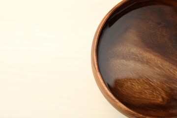 Bowl full of water on wooden table, space for text