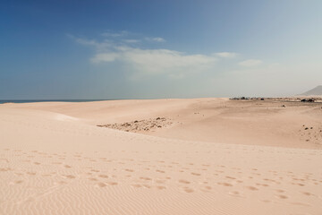 footprints on the desert of the dunes of Corralejo in Fuerteventura show the presence of tourists in the area