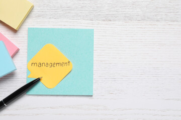 Paper note with word Management and pen on white wooden table, flat lay. Space for text