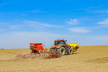 The drill is attached to the tractor, sows the field with grain.