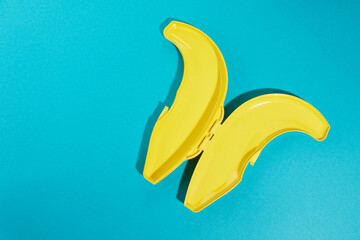Top view of plastic yellow banana case with sharpen shade isolated on blue  background.