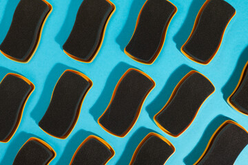 Top view of many yellow shoe sponges on blue background.