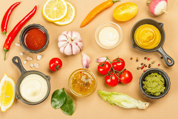 Set of sauces isolated on beige background. Ketchup, mustard, mayonnaise, wasabi, sweet curry