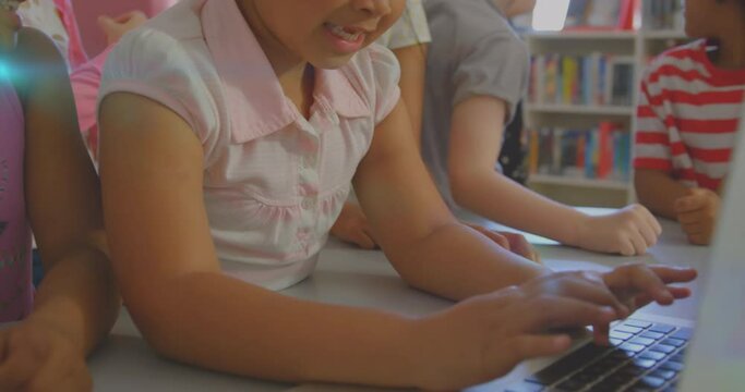 Animation of glowing light over diverse school children using laptop in classroom