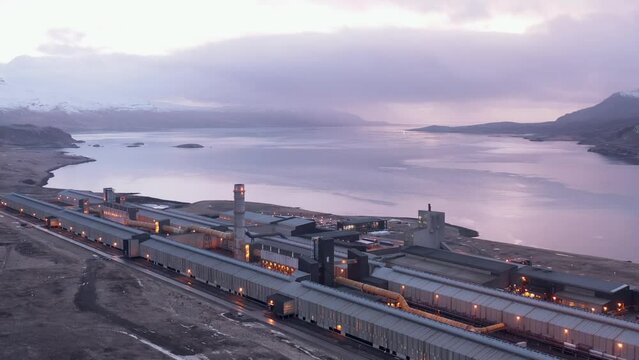 Bright sky sunrise at Rey&eth;arfj&ouml;r&eth;ur fjord with large aluminium smelter factory, aerial