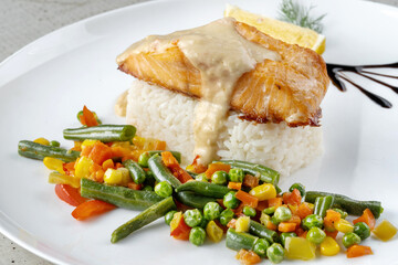 Bowl of rice with vegetables and salmon.