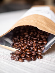 Brown bag with roasted coffee beans coming out of it