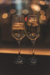 night shot of two glasses of prosecco with bokeh in the background