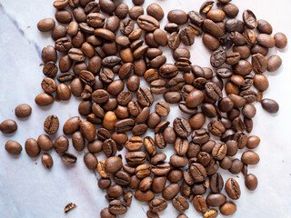 Roasted coffee beans on a white marble table