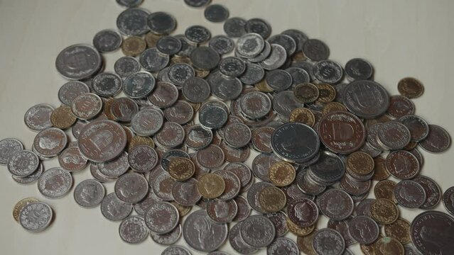 Swiss franc coins dropping on the table full of other coins