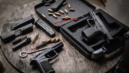 Disassembly and cleaning Maintaining a 9mm semi-automatic pistol on a wooden table. - obrazy, fototapety, plakaty