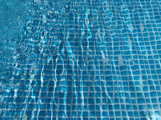 the reflecting water surface with waves in a blue pool