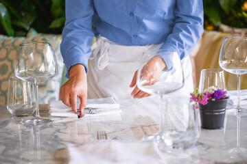 Obraz na płótnie Canvas Waitress serving the empty table of the luxury restaurant