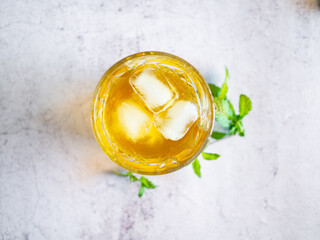 Top view of a glass cup with iced tea on a white table