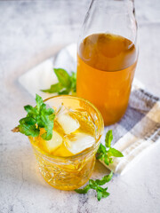 Iced tea with mint leaves on a white table