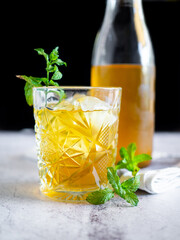 Iced tea with mint leaves on a white table
