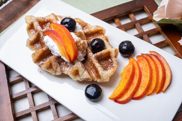 Delicious sweet dessert peach whipped cream waffle