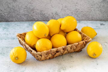 Fresh lemon. Organic lemons in a basket on a stone background. close up