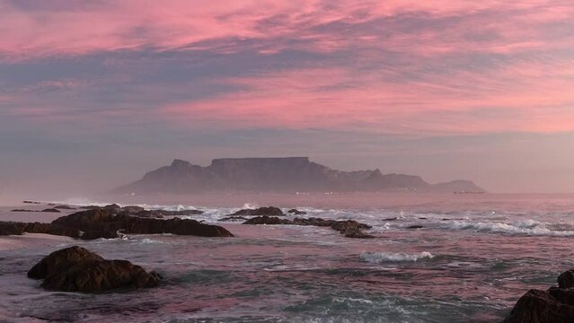 scenic view of tourist landmark destination table mountain cape town south africa from bloubergstrand with crushing waves at sunset