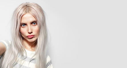 Naklejka premium Studio close-up portrait of funny pretty girl with blonde hair on white background with copy space, panoramic banner.