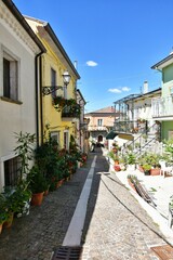 Fototapeta na wymiar A narrow street among the old houses of Greci, a village in the Campania region, Italy.