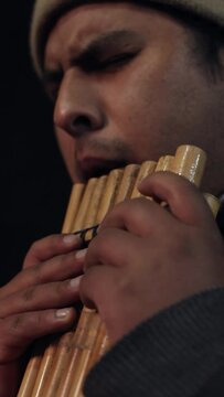 Closeup of a Bolivian man playing a siku