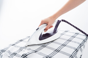 A Woman's ironing shirt with a modern steam iron. Home care concept.